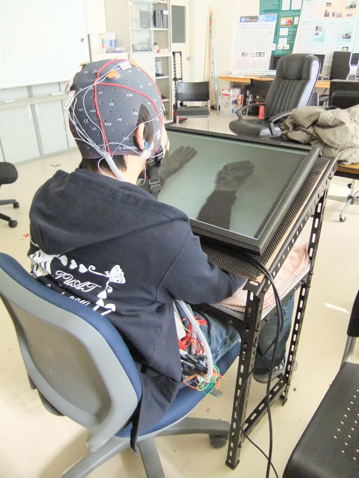  上肢動作の動画を見ながらERD発現訓練を行っている様子